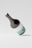 A large wine bottle mockup with a sleek design, featuring minimalistic white and mint green labeling. The bottle is tilted at an angle against a light gray background, casting a soft shadow on the surface.