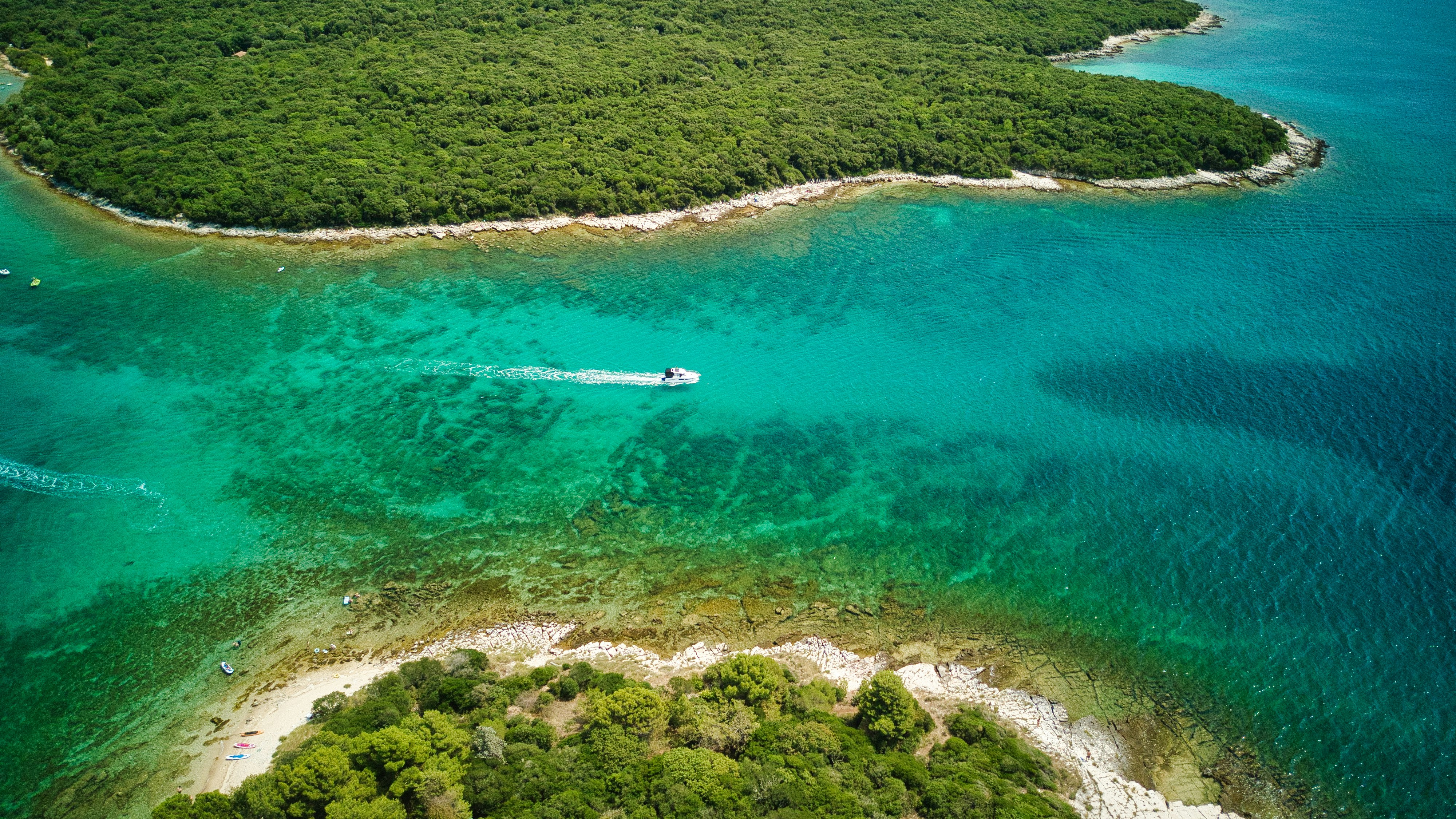an aerial view of an island with a boat in the water