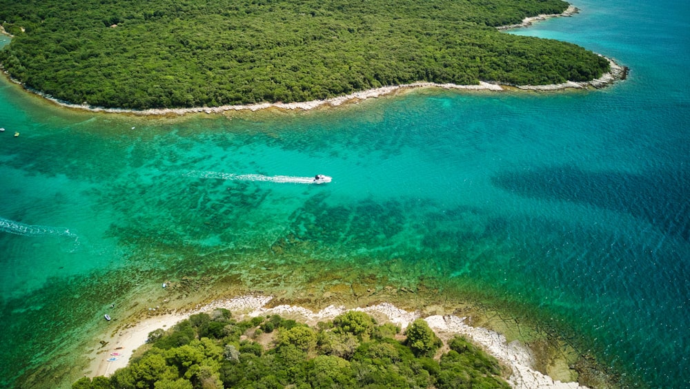 an aerial view of an island with a boat in the water