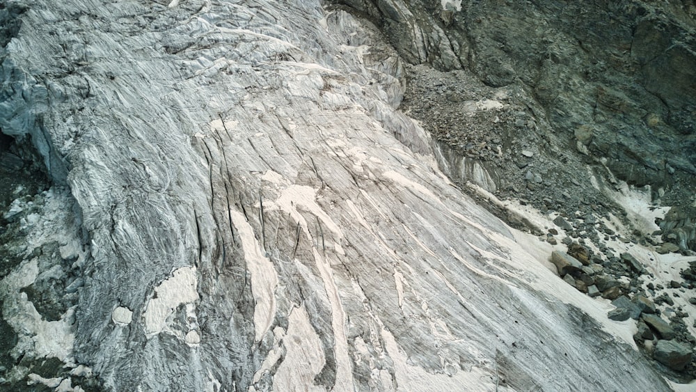 a man is climbing up a mountain with a snowboard