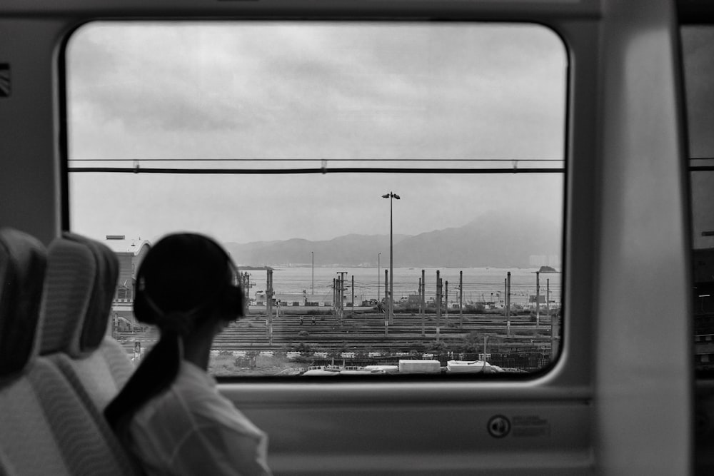 a woman sitting on a train looking out the window