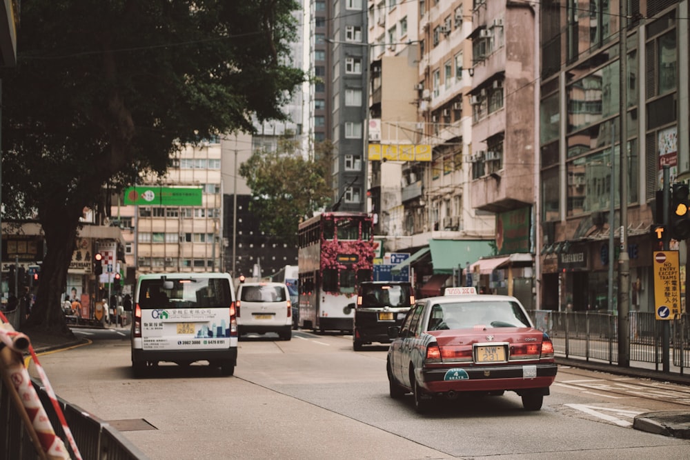 a city street filled with lots of traffic next to tall buildings