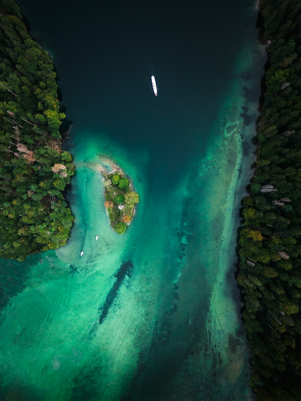 an aerial view of a body of water surrounded by trees