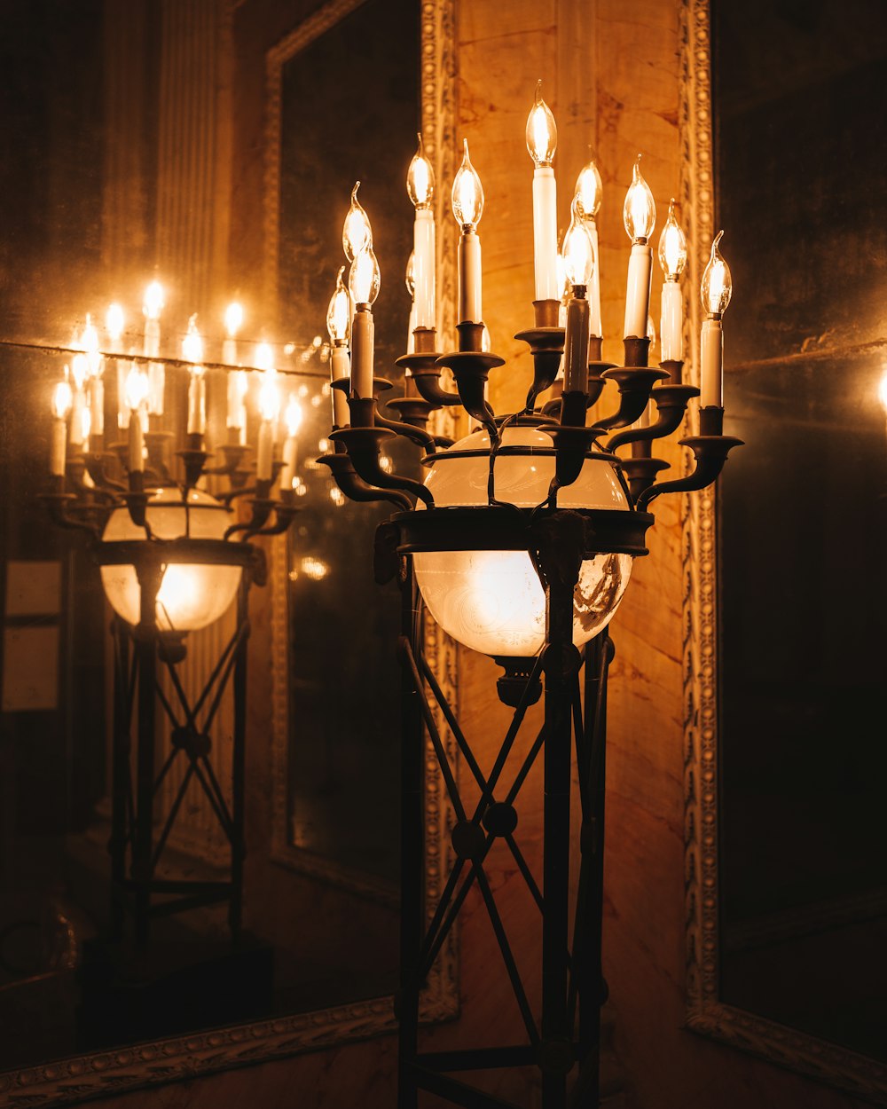 a chandelier with many lit candles in a room