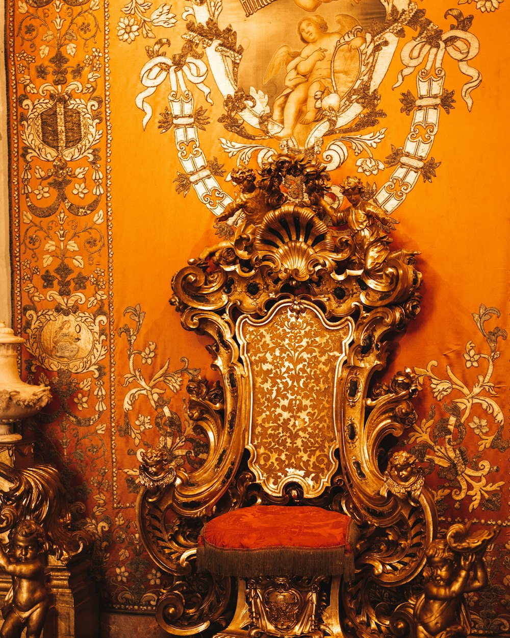 a golden throne with a red seat in a room