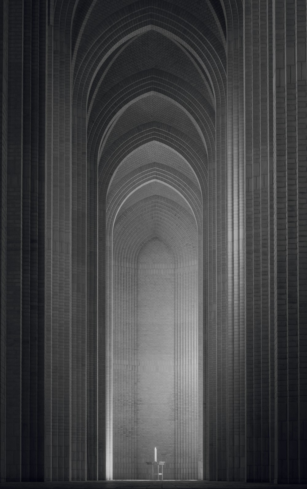 Une photo en noir et blanc d’un long couloir