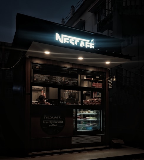 An automated coffee kiosk featuring a robotic arm serving coffee and snacks.