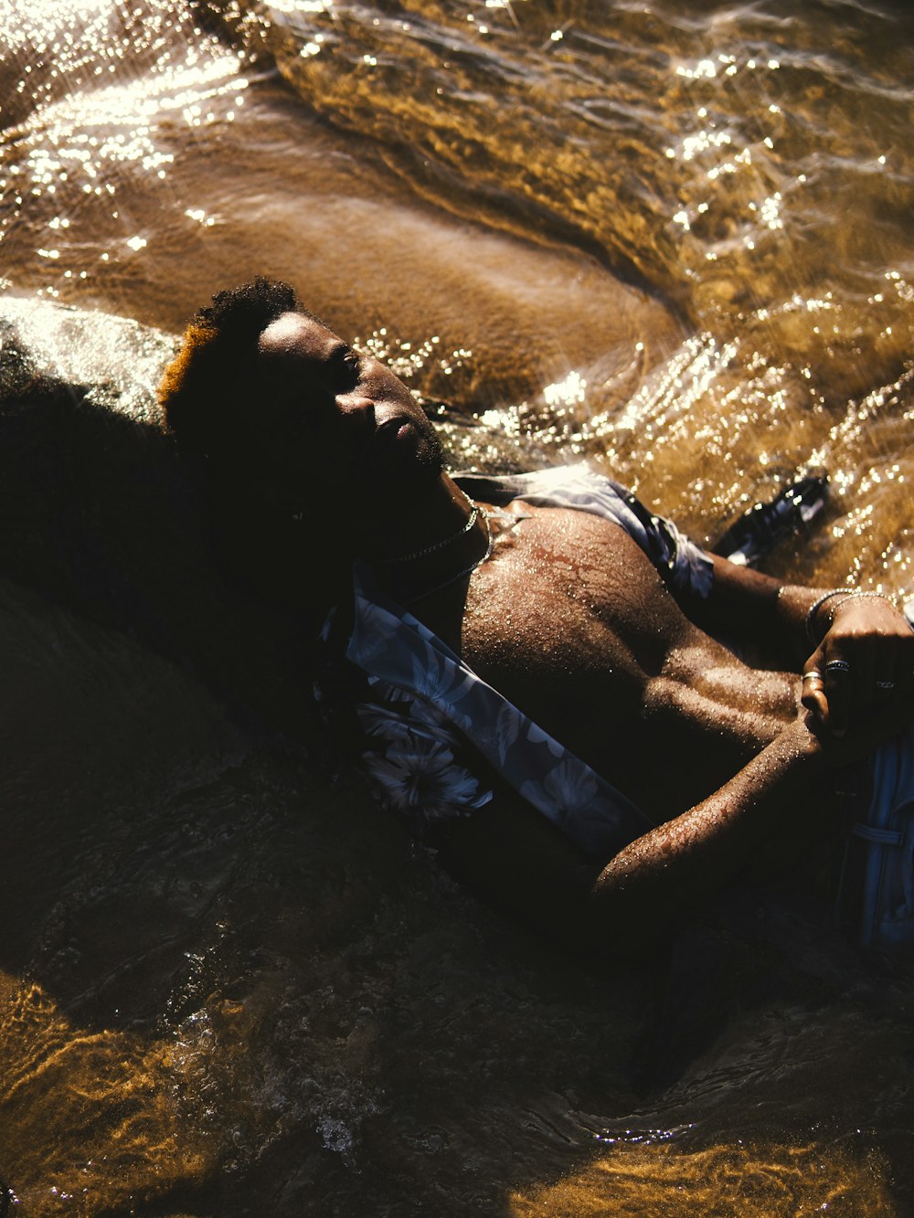 a man laying on top of a body of water