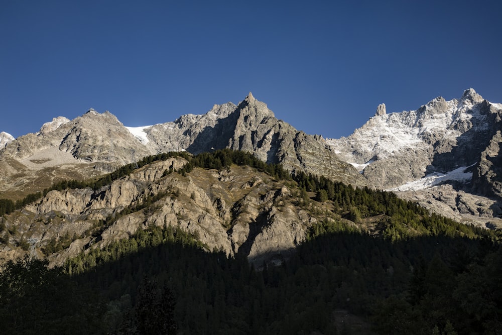 Blick auf eine Bergkette mit Bäumen an der Seite