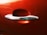 A shiny chrome car door handle is set against a glossy red car door. The reflections on the metallic surface add depth, with subtle shadows and highlights playing across the contours.