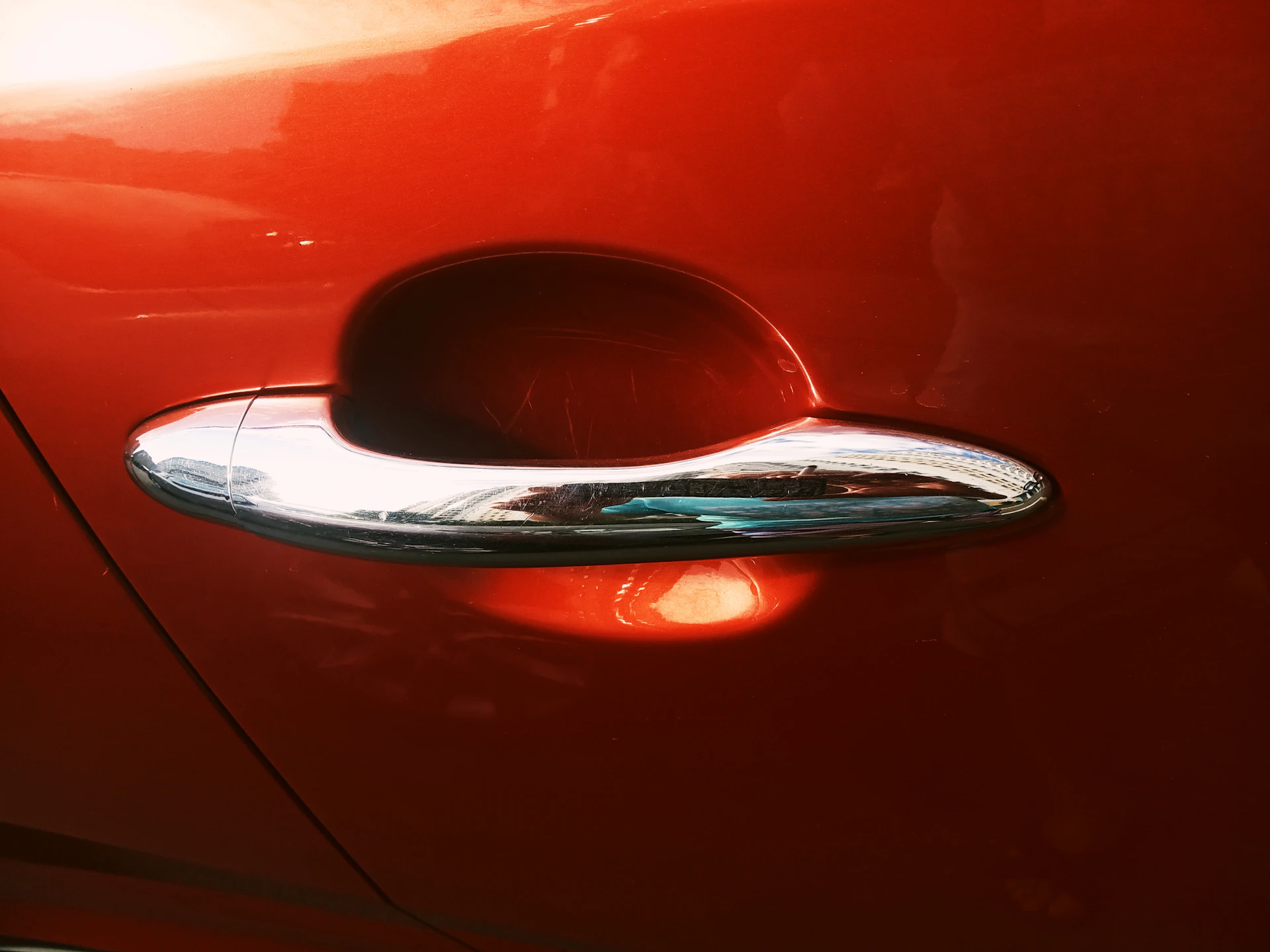 Reflective paintwork on a luxury car door, capturing deep shadows and bright highlights in a minimal, elegant composition.