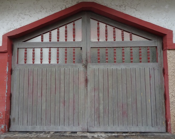 A classic wooden garage door with decorative windows on a cozy house.