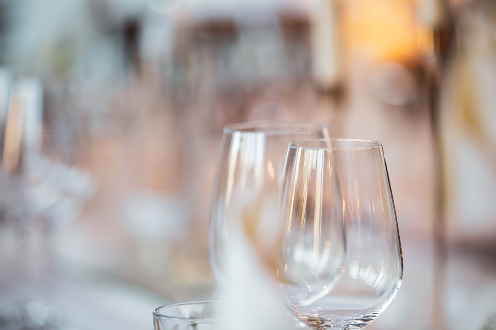 a close up of three wine glasses on a table