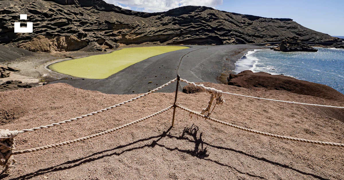 A roped off area with a body of water in the background photo – Free ...