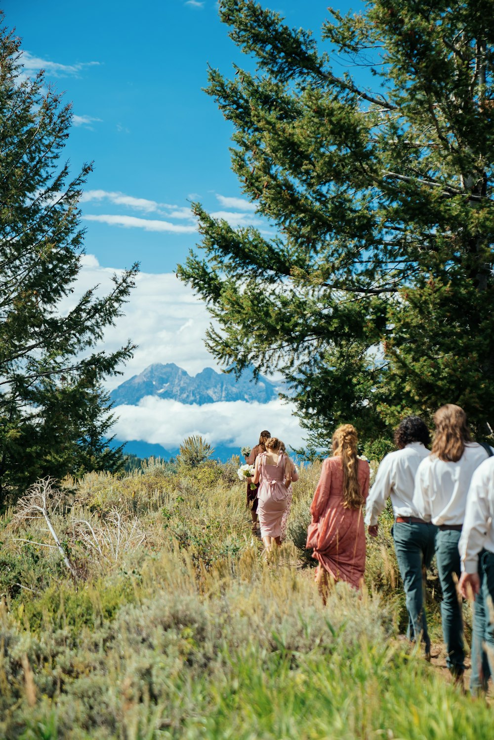 a group of people that are walking in the grass