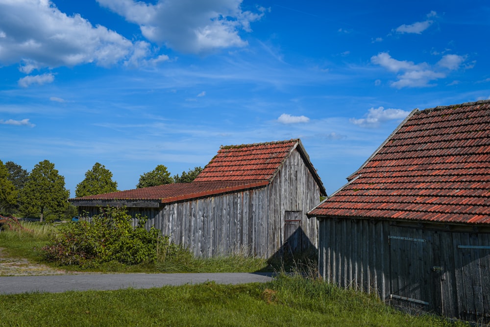 a couple of barns sitting next to each other on a lush green field