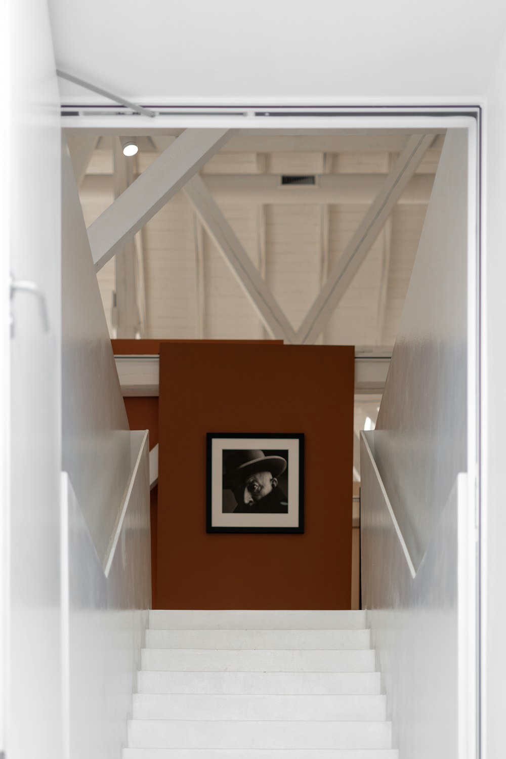 a staircase leading up to a room with a picture on the wall