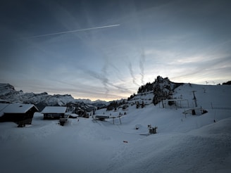 A serene image of a snowy mountain range at dusk.