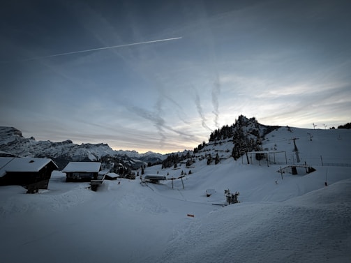 A serene image of a snowy mountain range at dusk.