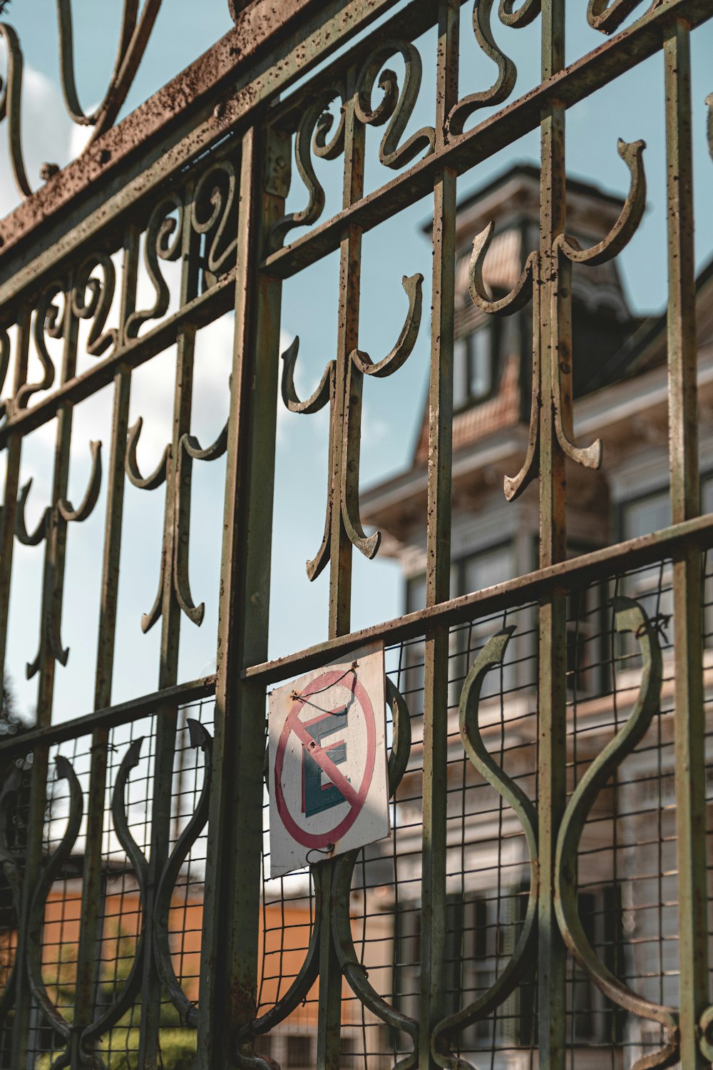 a close up of a fence with a building in the background