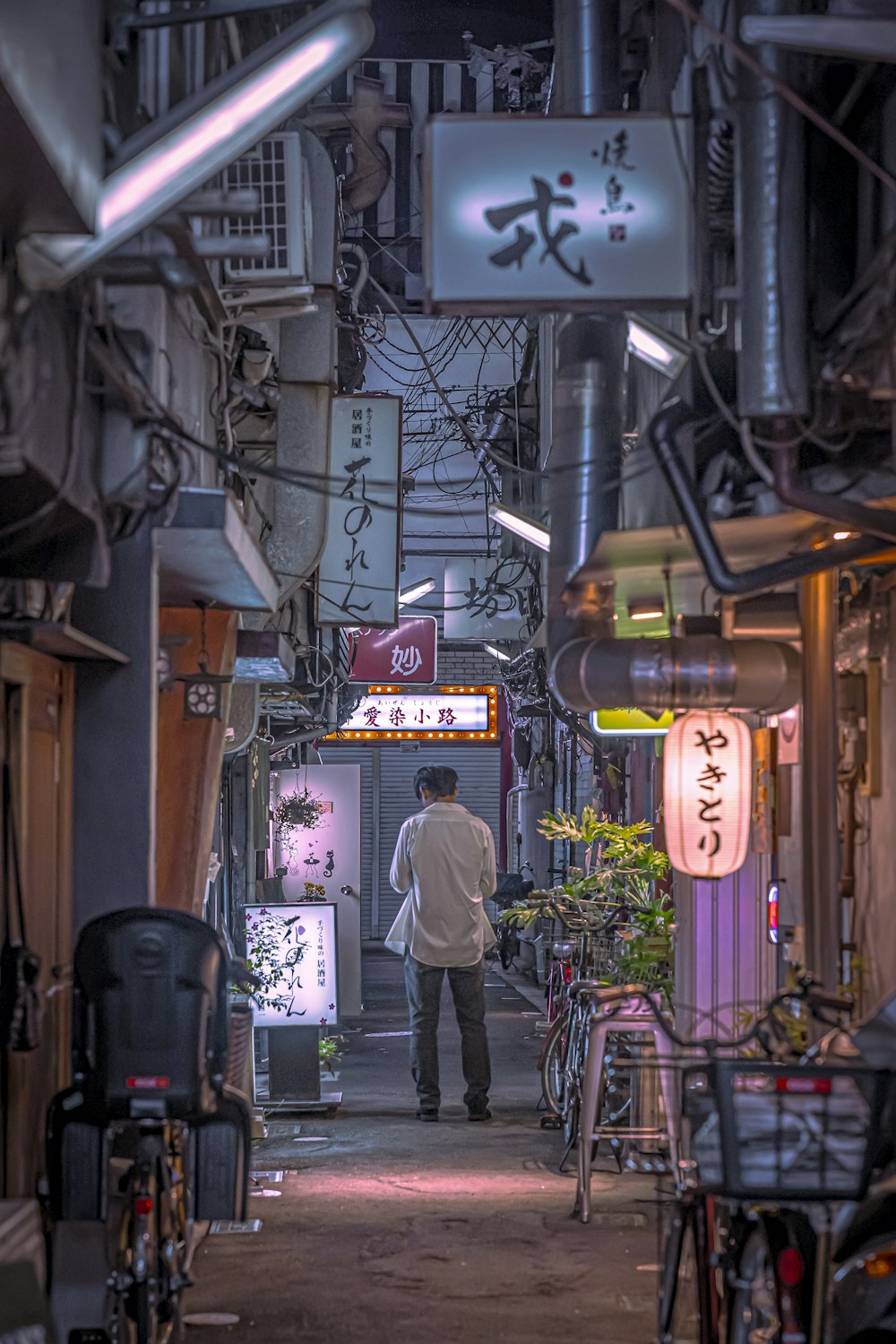 a man is walking down a narrow alley way