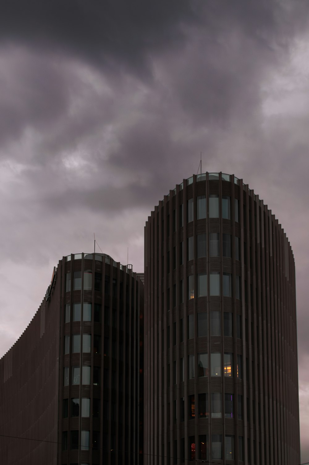 a couple of tall buildings sitting under a cloudy sky