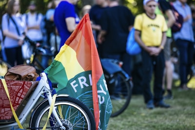 Close-up of a bright, colorful bike with double-sided flag banners fluttering behind.