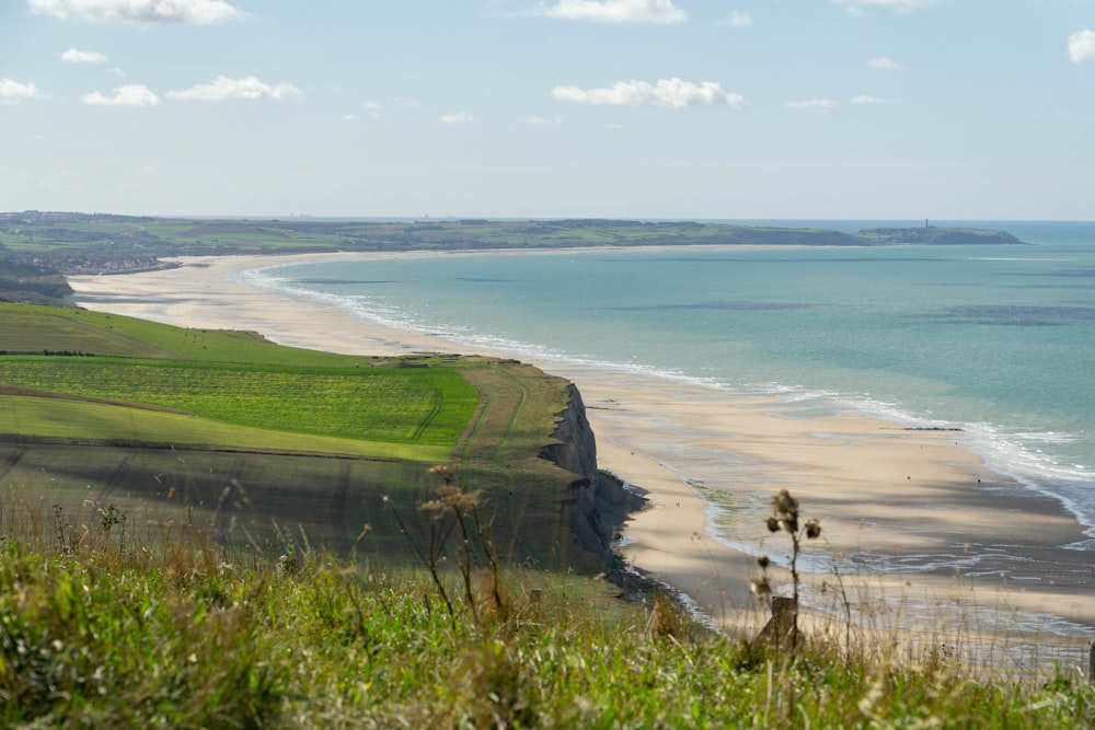 a view of a beach from a hill overlooking the ocean