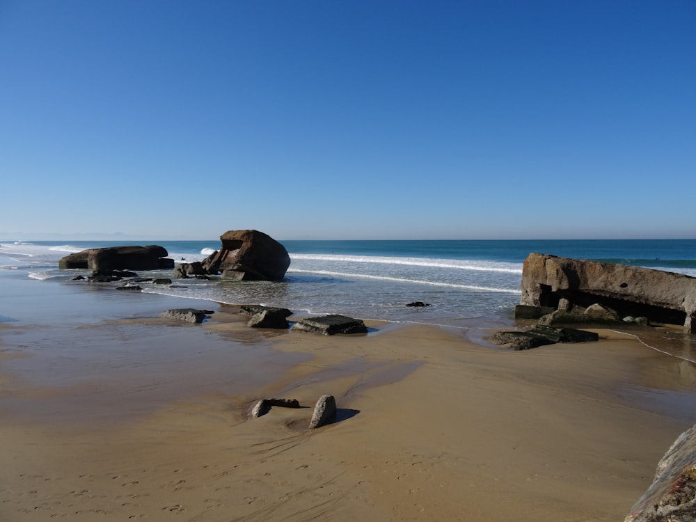 a beach with rocks and a body of water