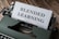 A vintage typewriter with an olive green body is set on a wooden surface, with a sheet of paper inserted that reads 'BLENDED LEARNING' in bold, capital letters.
