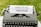 A vintage typewriter with a sheet of paper displaying the text 'DIGITAL DETOX' set against a backdrop of green grass.