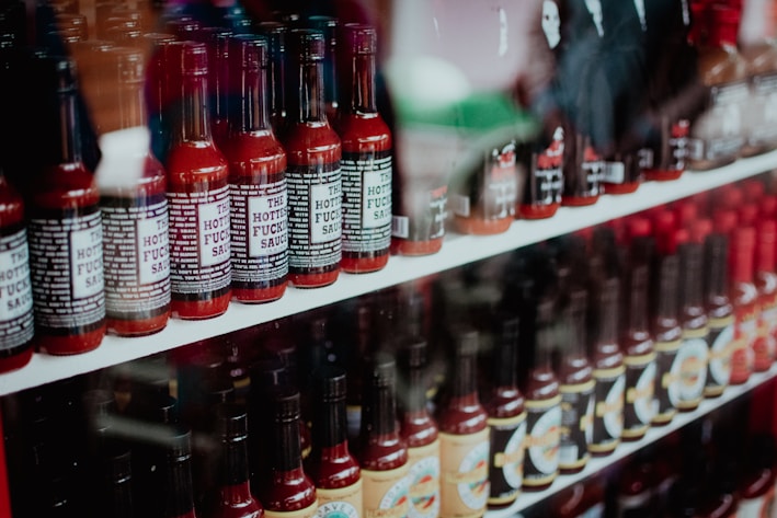 Close-up of artisanal Texas-made hot sauce bottles arranged on a rustic wooden table