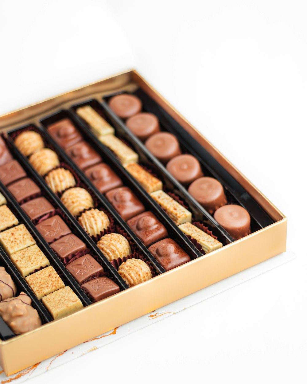 una caja de chocolates y galletas saladas sobre una mesa