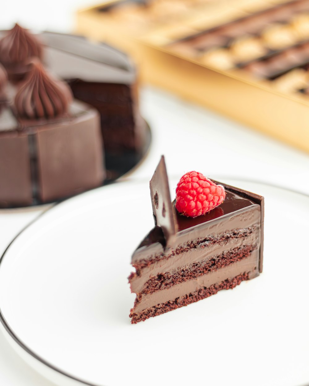 ein Stück Schokoladenkuchen mit einer Himbeere oben drauf