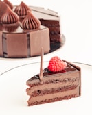 A slice of rich chocolate cake with a cherry on top.