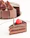 Close-up of a rich chocolate cake with raspberry filling and elegant frosting swirls