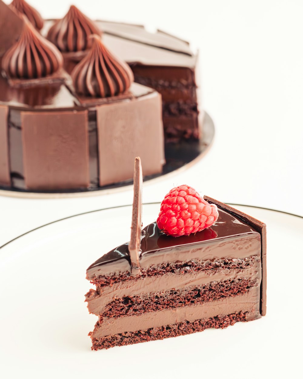 a slice of chocolate cake with a raspberry on top