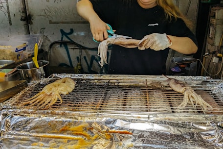 Close-up of traditional hand-beaten squid paste being prepared in a rustic kitchen.