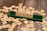 Several wooden letter tiles are scattered across a wooden surface, with one set of tiles arranged on a green tile holder to form the word 'FIGHT'. The tiles show various letters and point values.