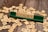 Several wooden letter tiles are scattered across a wooden surface, with one set of tiles arranged on a green tile holder to form the word 'FIGHT'. The tiles show various letters and point values.