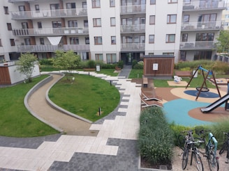A vibrant new apartment complex with green spaces and families enjoying the community.