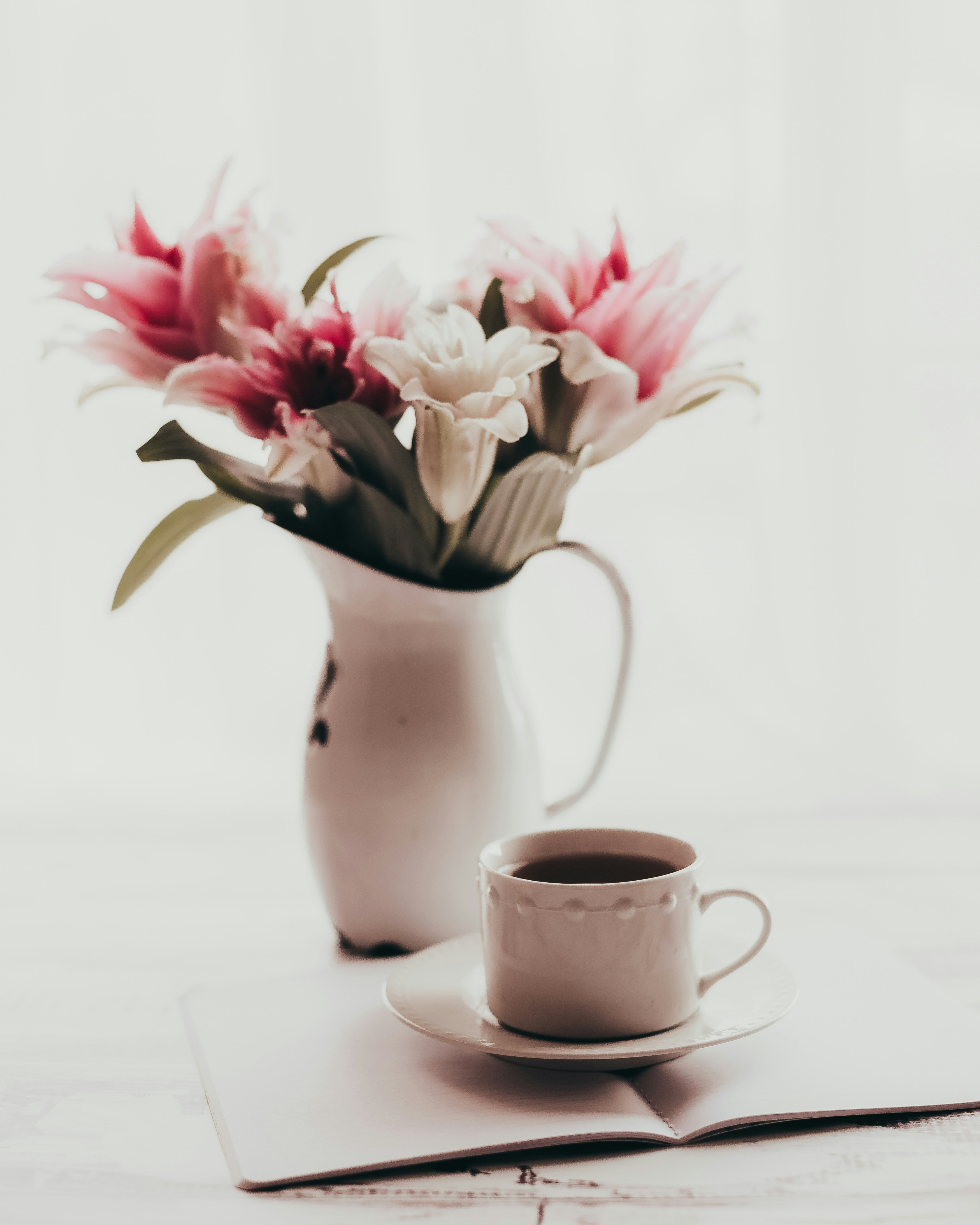 a cup of coffee and a vase of flowers