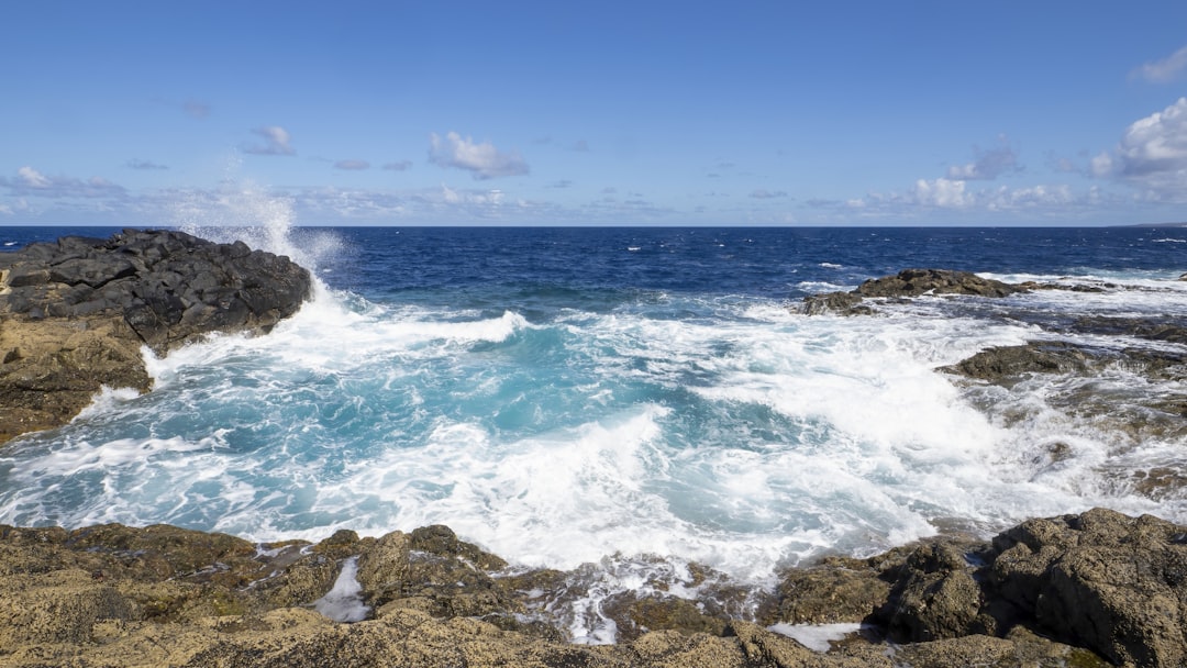 a rocky shore with waves crashing against the rocks,