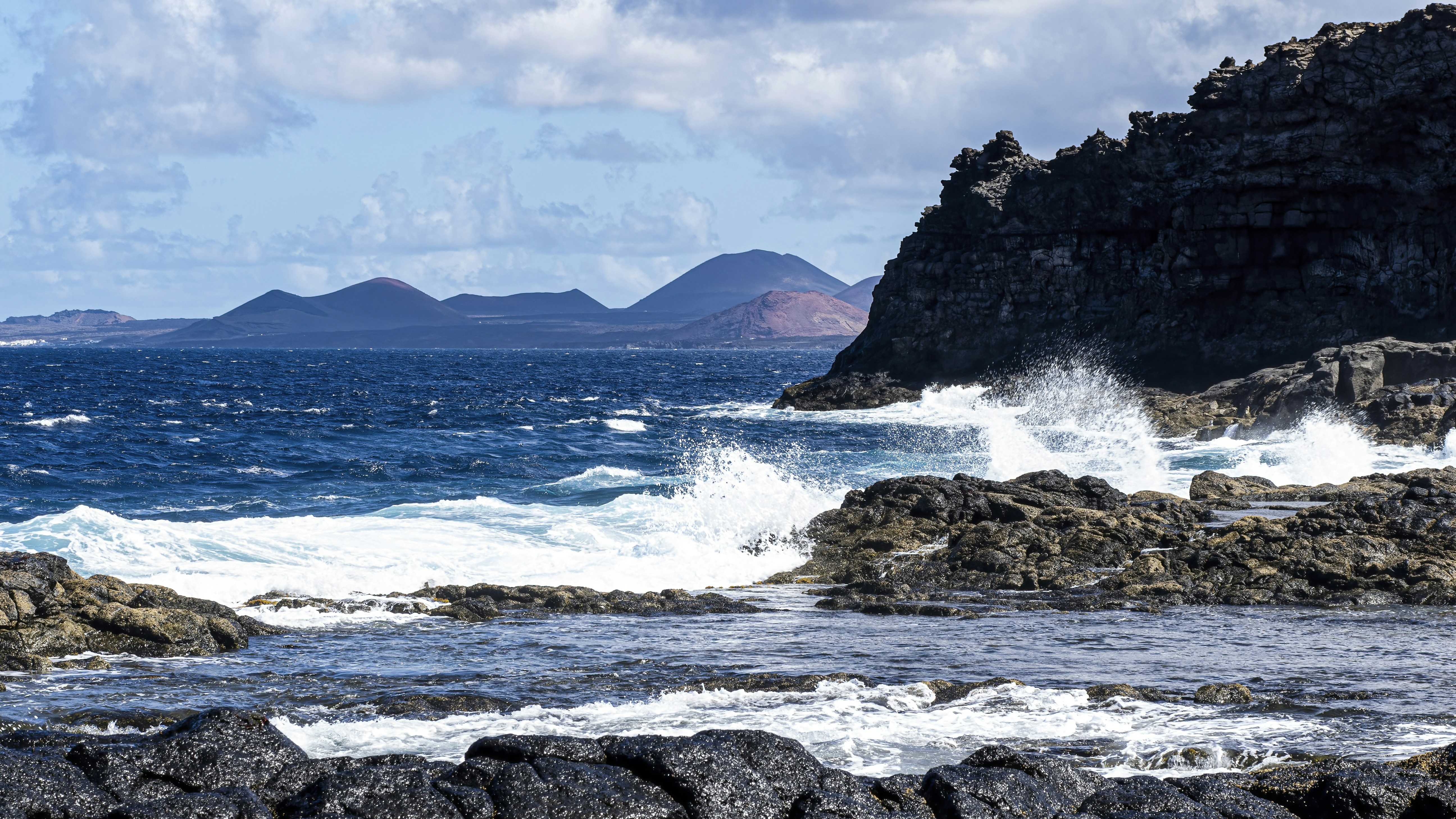 a large body of water near a rocky shore, 