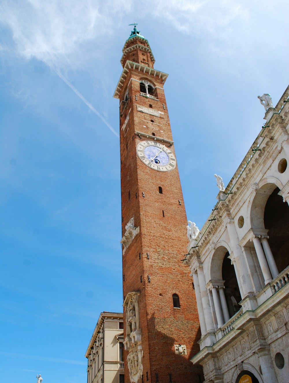 Un'alta torre dell'orologio in mattoni che domina una città