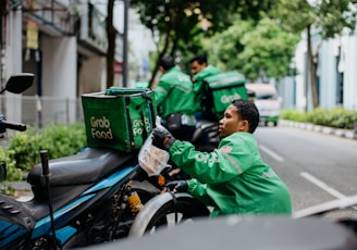 a man in a green jacket sitting on a motorcycle