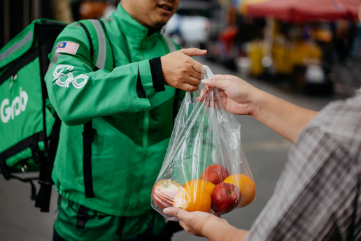 A delivery truck unloading fresh produce at a bustling food distribution center in Indonesia.