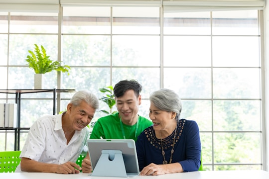 A business team smiling while using a tablet showing a visual assistant in action.