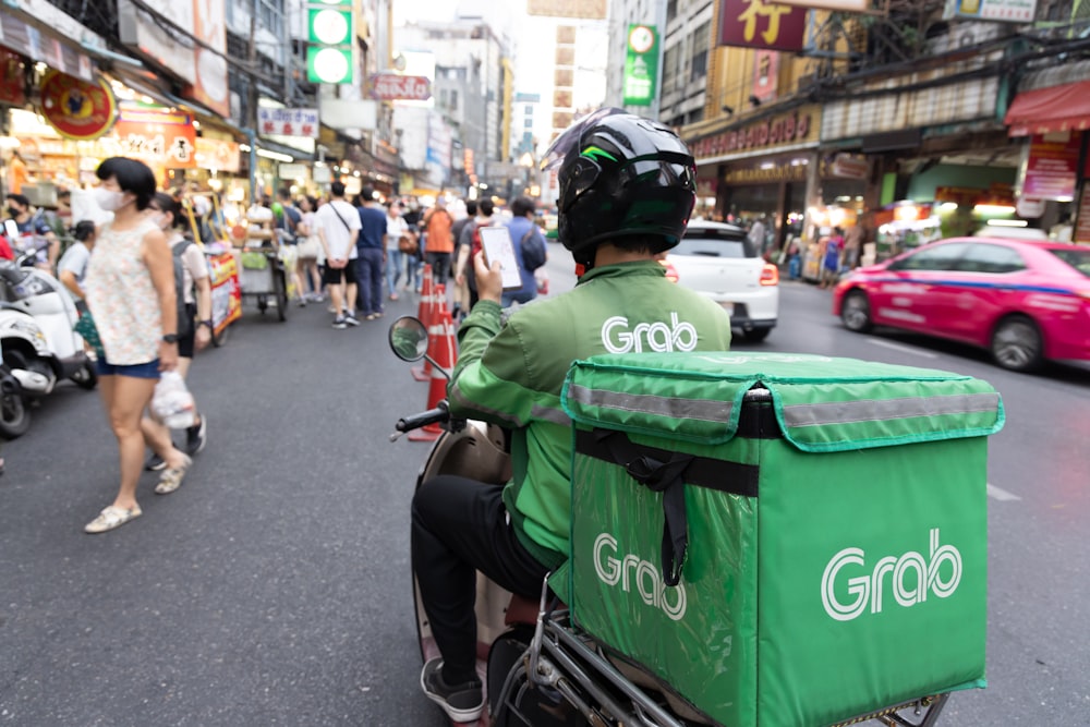 a man riding a scooter down a busy street