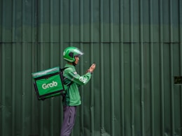 a man in a green jacket is holding a green bag